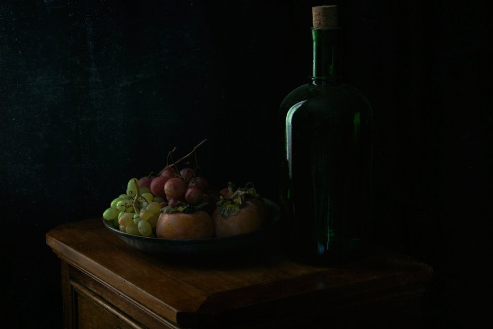 Somber ogende druiven en fles door Ramiz Sahin