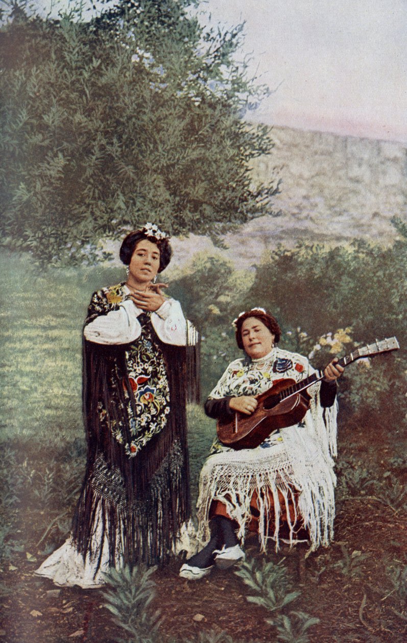 Spanje. Terwijl haar metgezel gitaar speelt, klapt het jonge meisje zachtjes in haar handen. De meeste Spaanse dansers geven de voorkeur aan deze vorm van begeleiding. 1920 door Unknown