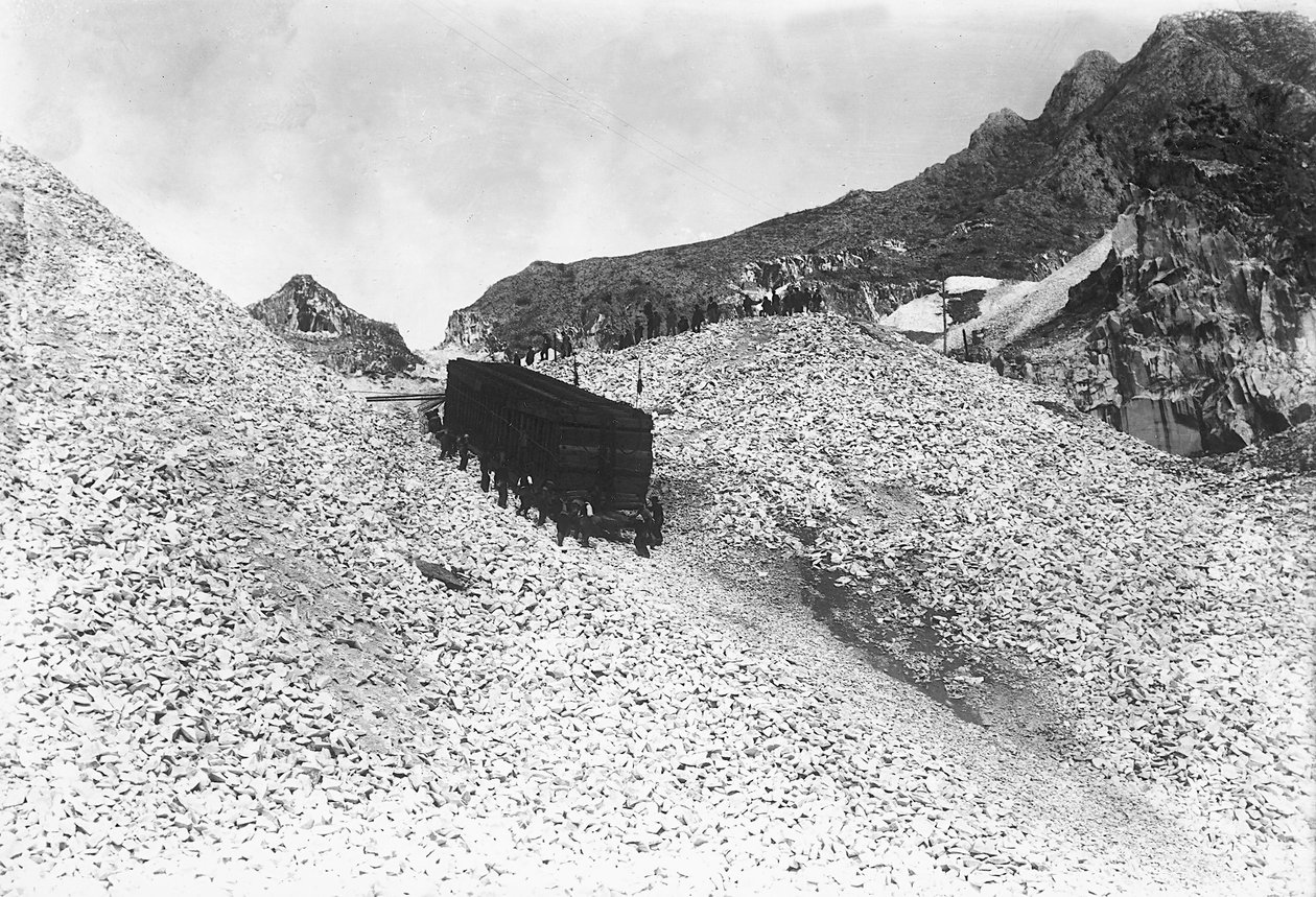 Transport van een enorm konvooi met marmer, langs een weg bij een groeve in de Apuanische Alpen, Toscane (zw/w foto) door A. Corsini