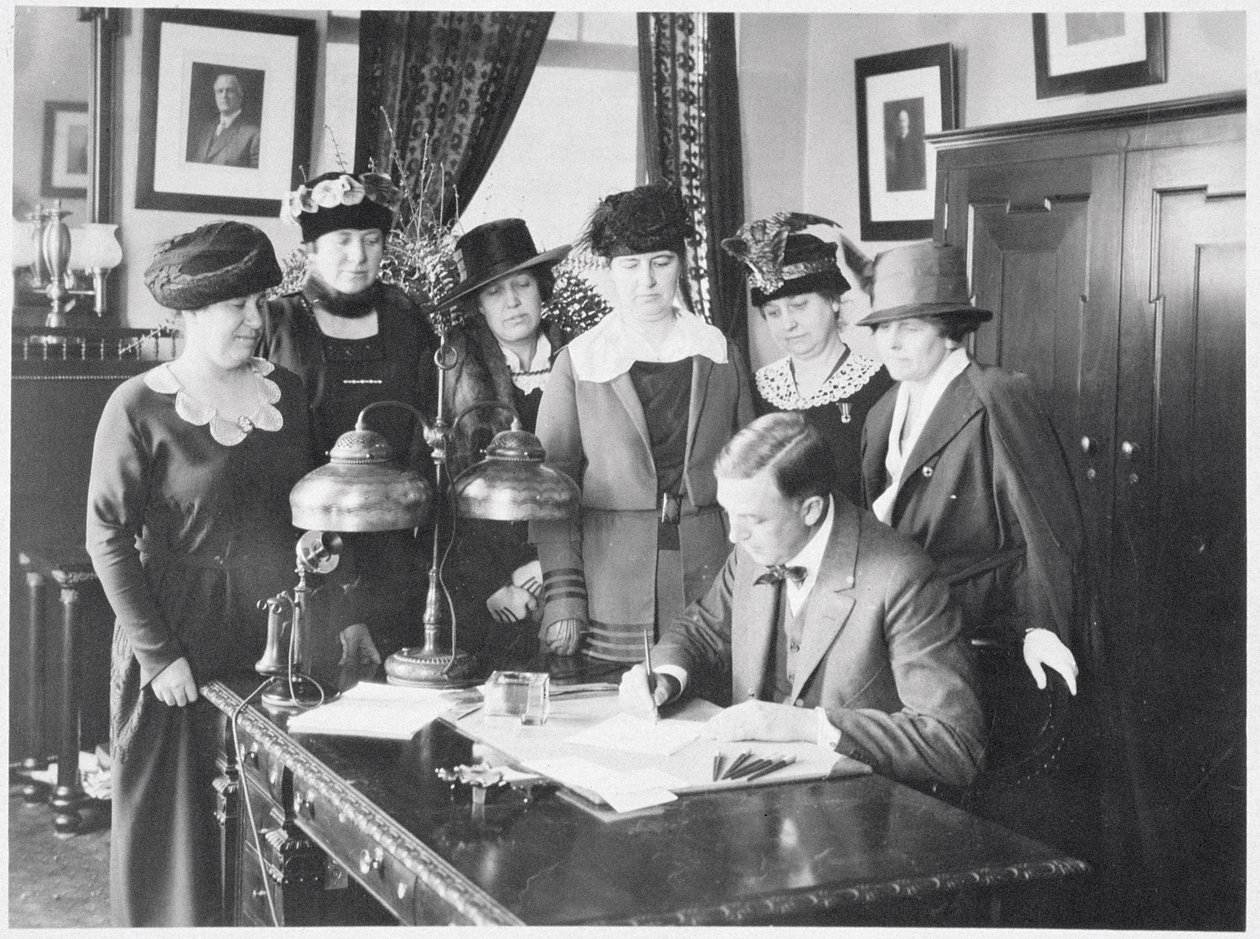 Gouverneur Carl Elias Milliken ondertekent de kiesrechtwet terwijl zes vrouwen toekijken, 1917 door American Photographer