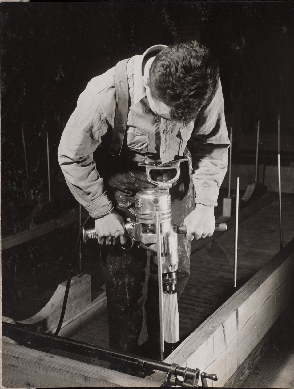 [Man gebruikt een handbediende machine om een stuk hout te bewerken]. door Arnold Eagle