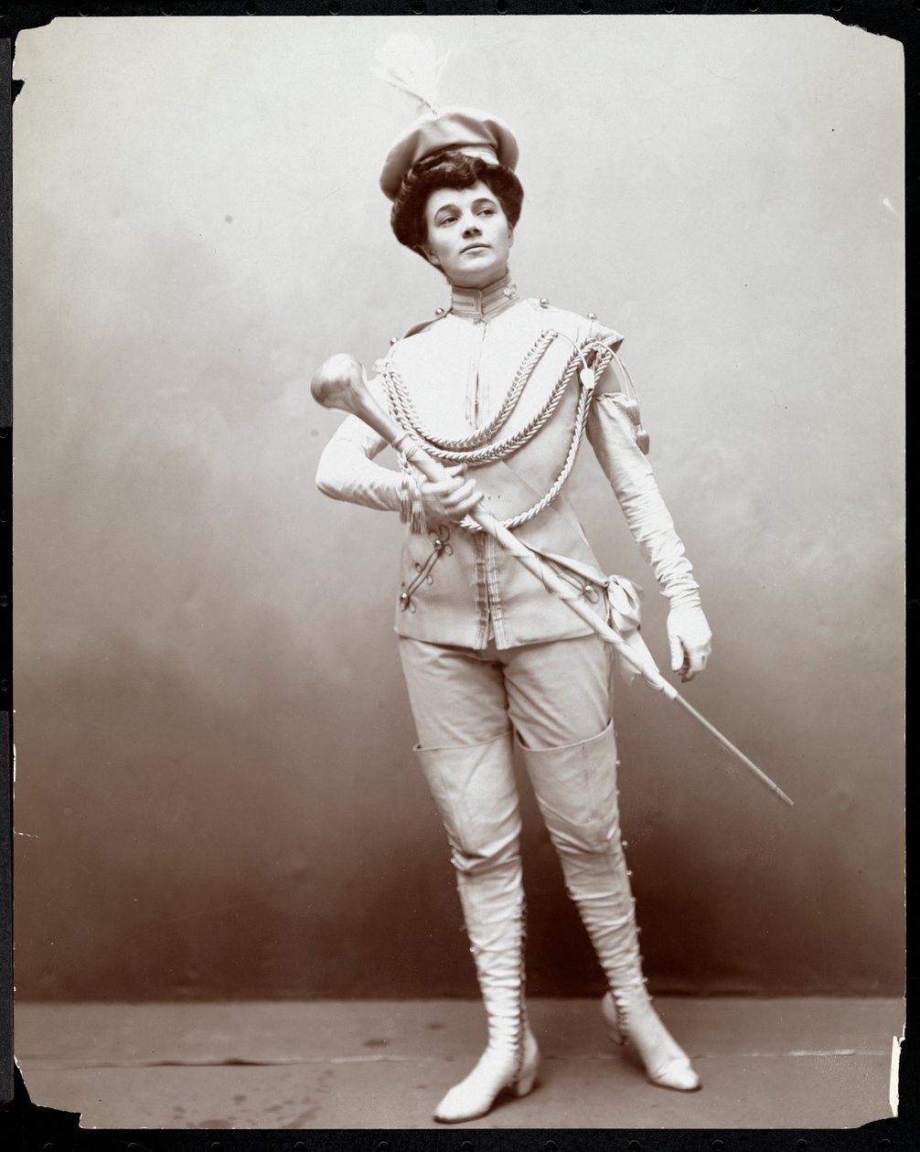 Een vrouw die een uniform modelleert, met een baton, ca. 1898 door Byron Company