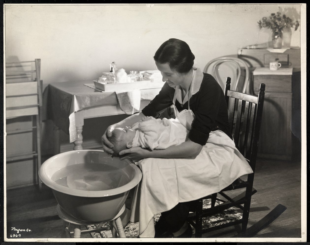 Een vrouw wast het hoofd van een baby in het Maternity Center Association op 211 East 57th Street, New York, 1934 door Byron Company