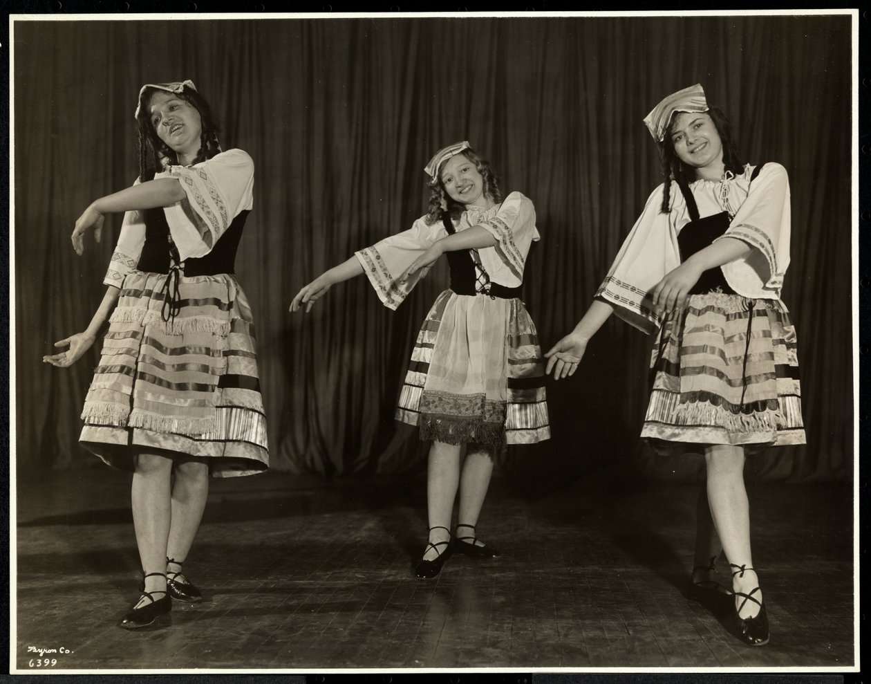 Drie blinde jonge vrouwen in kostuum dansen op het podium in een toneelstuk bij de New York Association for the Blind, New York, 1931 door Byron Company
