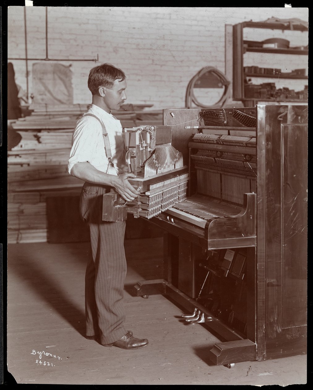 Man aan het werk in de Hardman, Peck en Co. pianofabriek, New York, 1907 door Byron Company
