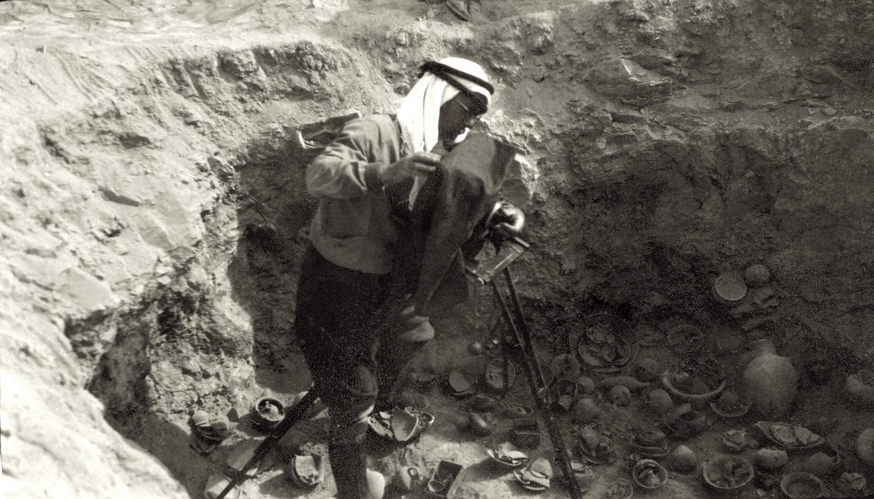 Professor John Garstang fotografeert gebroken aardewerk in situ bij de opgravingen van Jericho, 1930-36 door English Photographer
