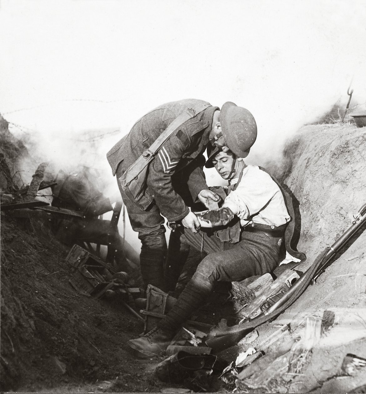 Eerste hulp ontvangen van zijn sergeant in een loopgraaf tijdens de hevige strijd bij Peronne, 1918 door English Photographer