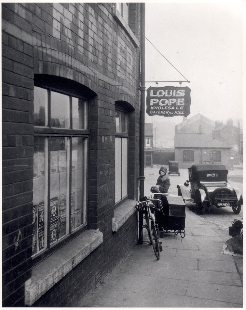 Vrouw met een kinderwagen buiten Louis Popes pand, Lady Lane, Leeds, 1931 door English Photographer