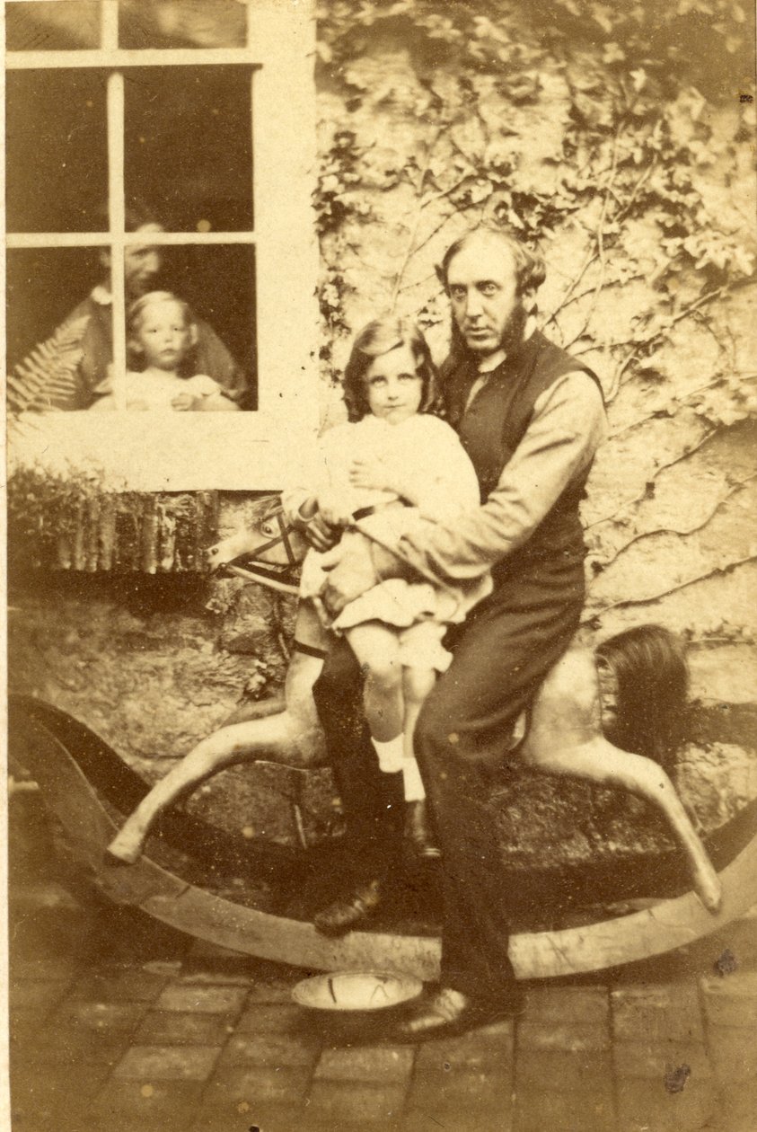 Vader en dochter zittend op een hobbelpaard met broer en moeder kijkend door het raam, 1860s door English Photographer