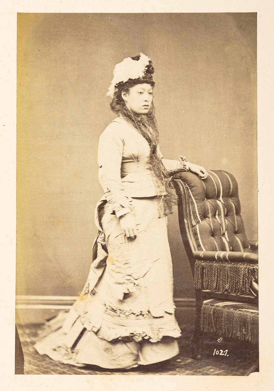 Japanse vrouw in Europese kleding, Volledig staand studiportret van een jonge Japanse vrouw in westerse kleding en hoed, Fotograaf: Onbekend Lucas Collectie: Fotografisch verslag van de wereldreis van Charles James en Morton P, Lucas door English Photographer