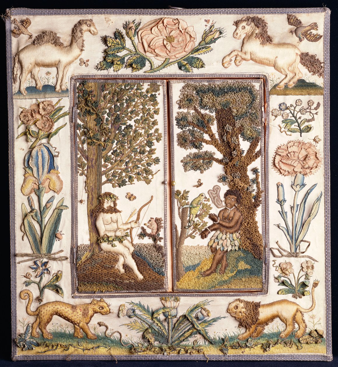 Een verhoogd werk geborduurde spiegel met een primitieve jager met een boog en pijl, en een zwarte met een papegaai, het frame met een kameel, paard, leeuw, luipaard, roos, iris en andere bloemen door English School