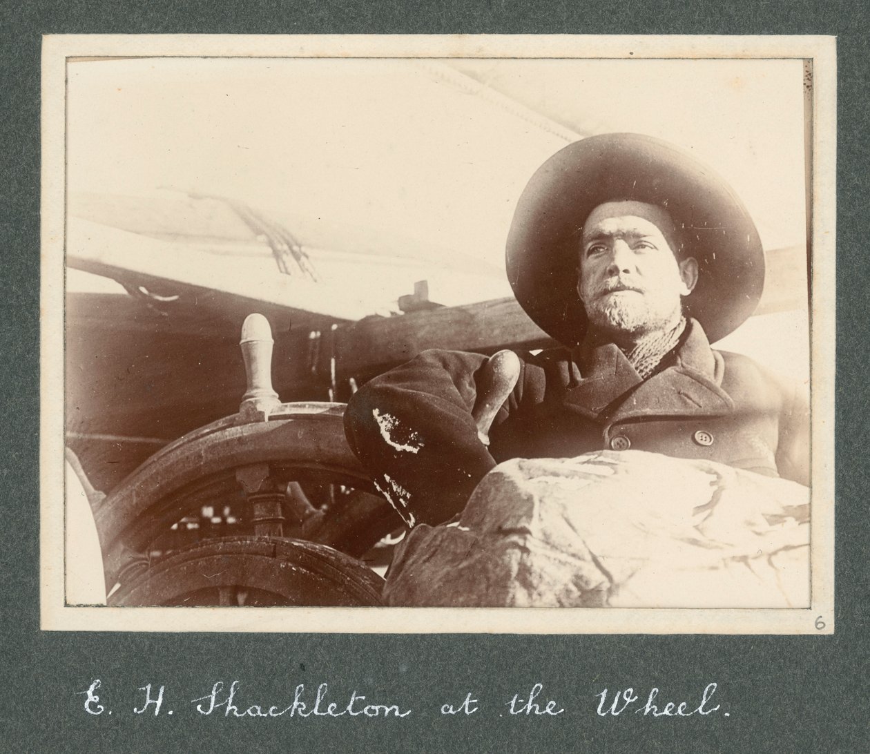E H Shackleton staand bij het stuur van de 