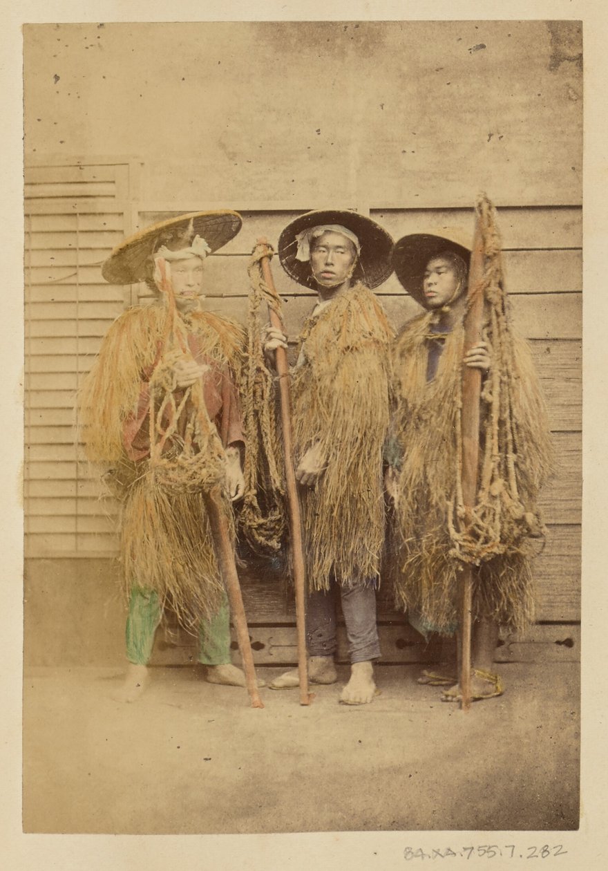 [Drie Japanse mannen in grasgewaden en breedgerande hoeden]. door Felice Beato