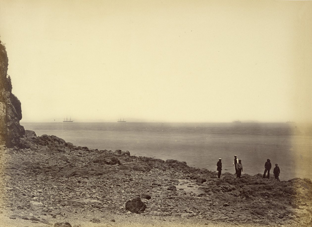 [Zicht op kust met schepen aan horizon en vijf figuren staand op strand]. door Felice Beato