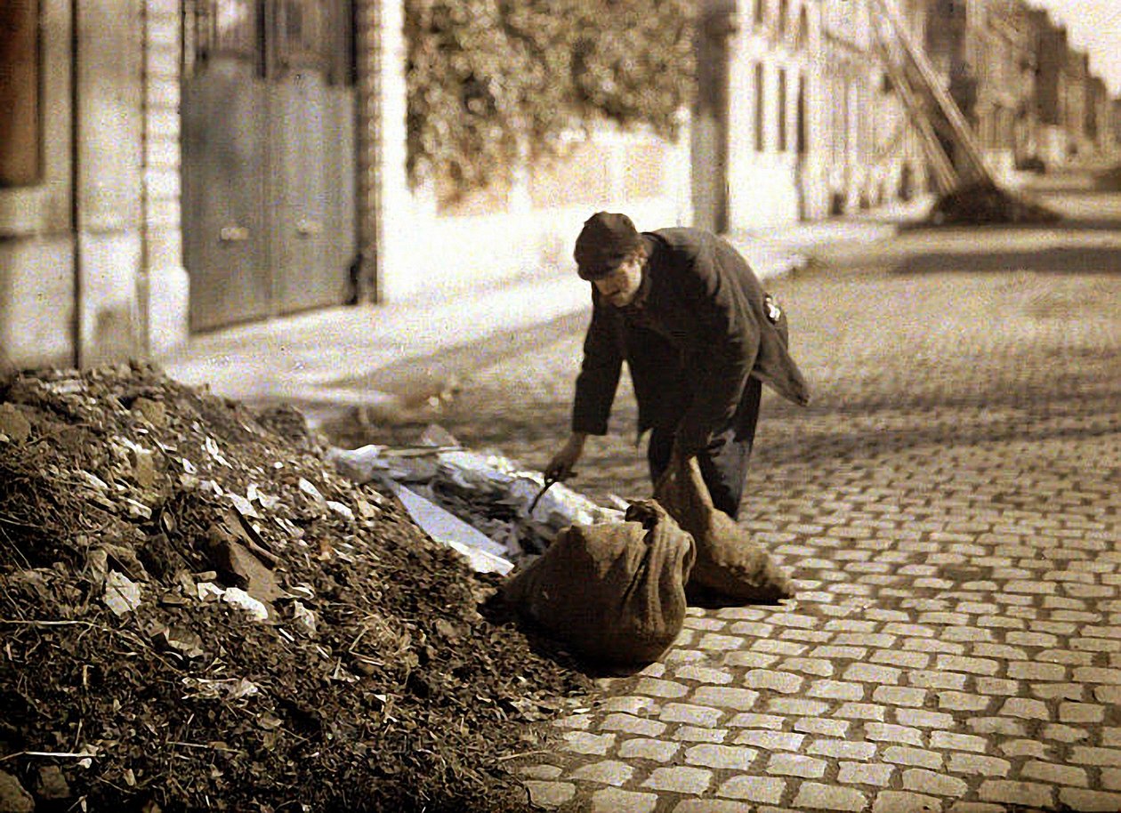 Voddenraper op zoek naar bruikbare spullen uit een stapel, Reims, Marne, Frankrijk, 1917 (autochroom) door Fernand Cuville