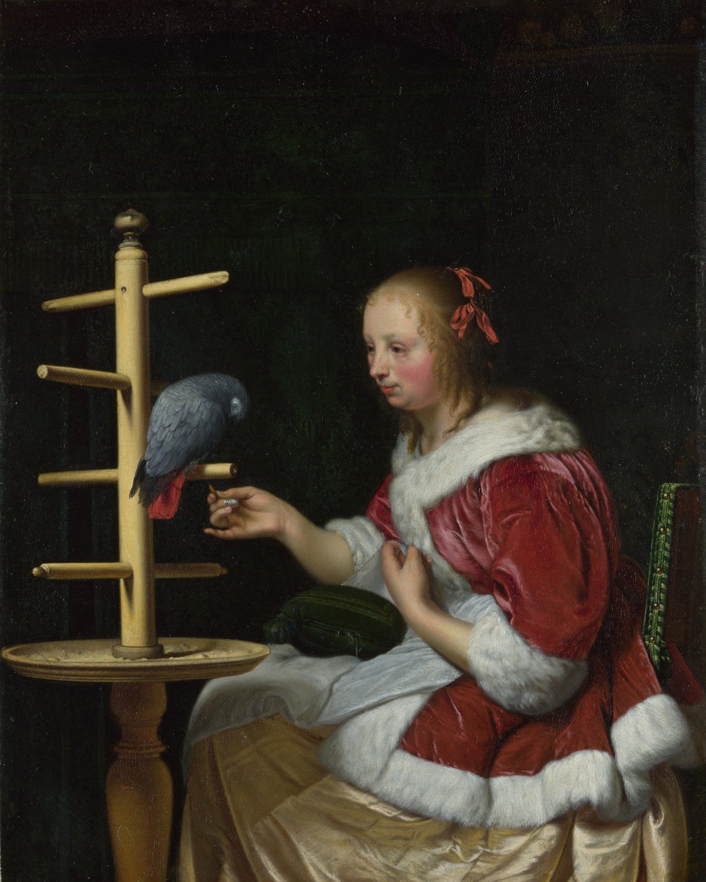 Een vrouw in een rood jasje die een papegaai voedt door Frans van Mieris the Elder