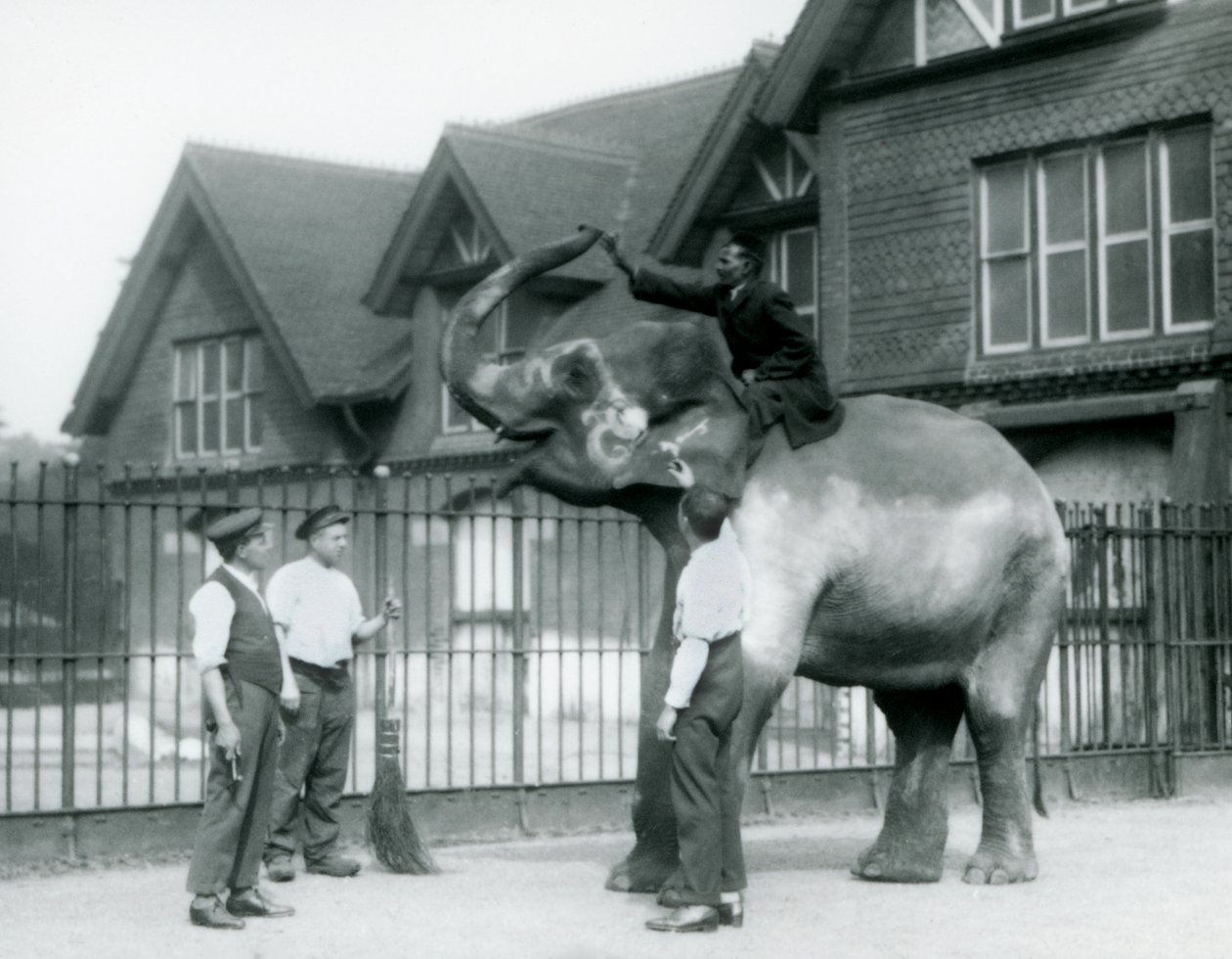 Een Versierde Indiase Olifant, met drie verzorgers en trainer, buiten het Olifantenhuis in de London Zoo in 1927 door Frederick William Bond