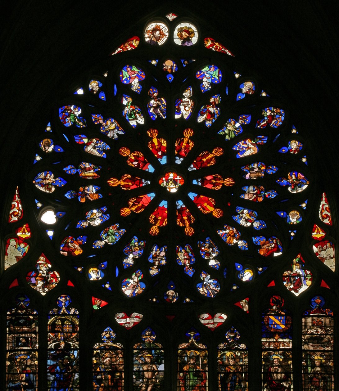 Raam w135 met God, serafijnen, muzikale engelen en tien van de apostelen. De lancetten hieronder bevatten laat 16e-eeuwse figuren, de patroonheiligen van de toenmalige kanunniken: St. Jacobus, St. Christoffel, St. Karel de Grote door French School