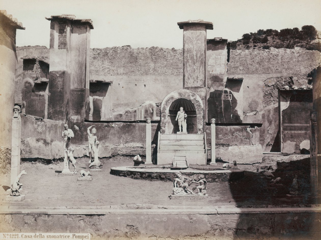 Gedeeltelijk uitzicht op de verhoogde tuin van het Huis van Marcus Lucretius in Pompeii, versierd met marmeren beelden en hermen. In het midden een fontein met een nis. Op de achtergrond fragmenten van muurschilderingen door Giorgio Sommer