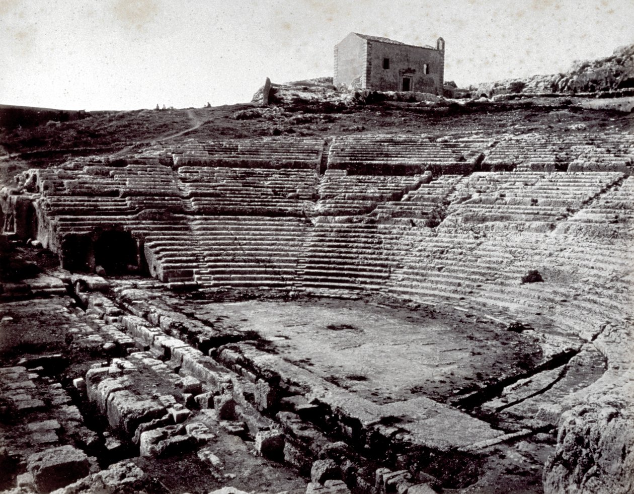 De overblijfselen van het Griekse Theater in Siracusa in het Monumentale Park van de Neàpoll. Op de voorgrond de halfronde orkestbak en de cavea door Giorgio Sommer