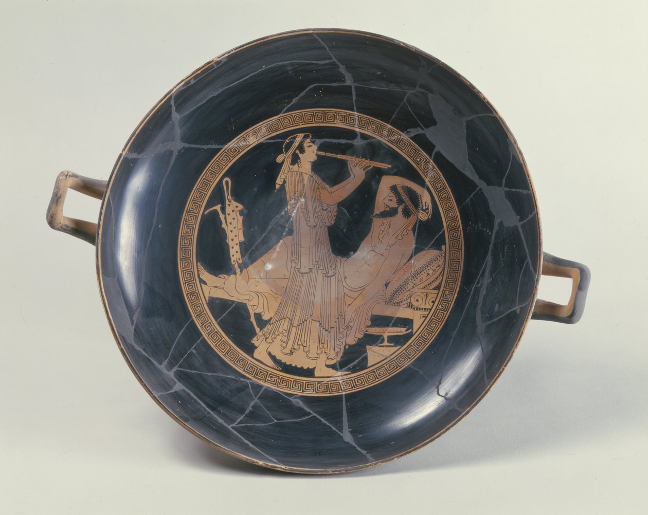 Attische roodfigurige beker met afbeelding van een vrouw die een dubbele fluit bespeelt (aardewerk) door Greek