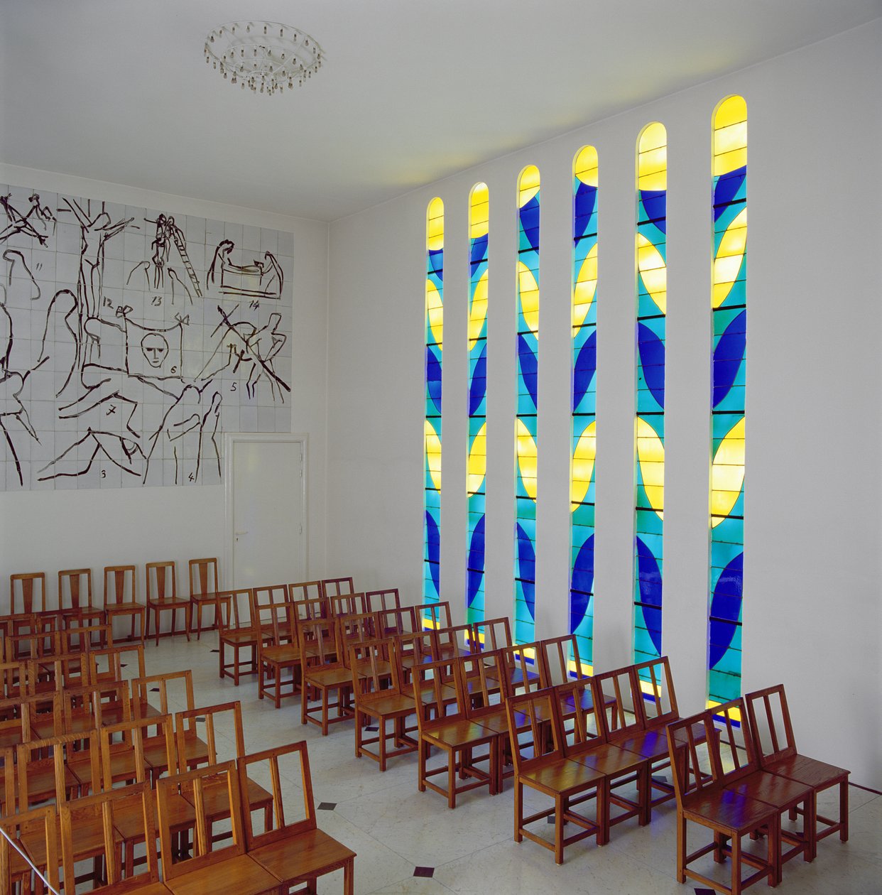 Zicht op het schip, het glas-in-lood zijraam en de kruiswegstaties in de Rozenkranskapel, Vence door Henri Matisse