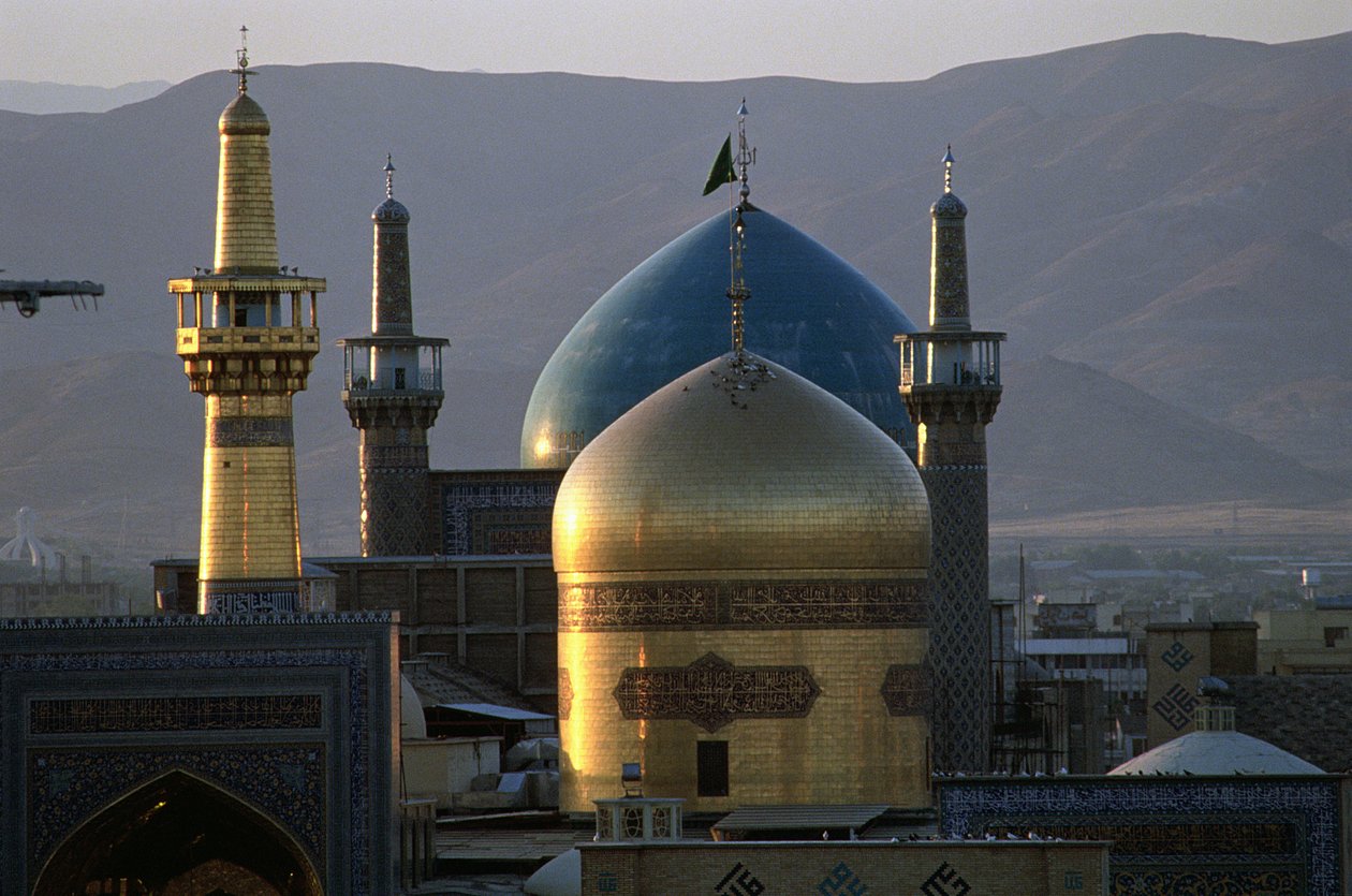 De geheel gouden koepel en minaret van het heiligdom van Imam Reza, de 8e Sjiitische Imam, met de Timuridische Gowhar Shad Moskee erachter door Islamic School
