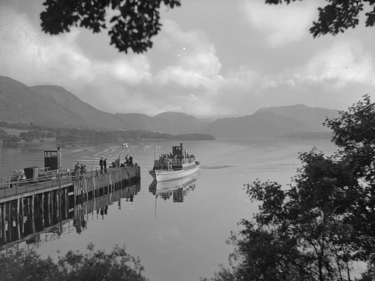 Een boot met mensen op een meer bij een steiger, bergen op achtergrond door Joseph Hardman