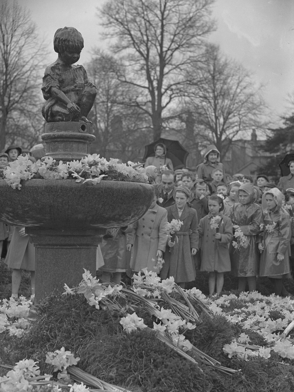 Kinderen plaatsen bosjes narcissen op fontein met standbeeld erop door Joseph Hardman