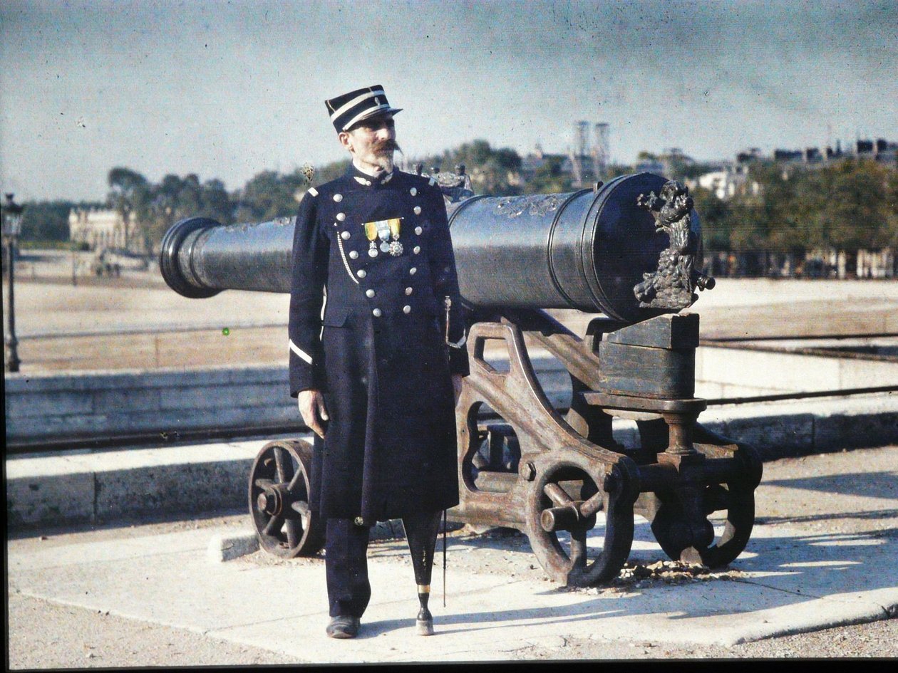Een soldaat in uniform met drie medailles staat naast een kanon in Parijs door Jules Gervais Courtellemont