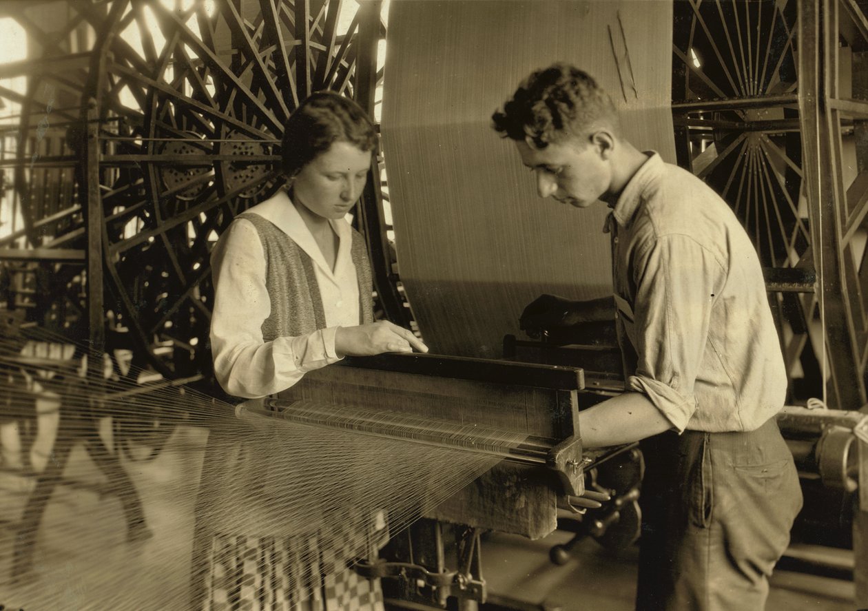 Een jongen en een meisje werken aan een weefgetouw in de Cheney Silk Mills in South Manchester, Connecticut. door Lewis Wickes Hine