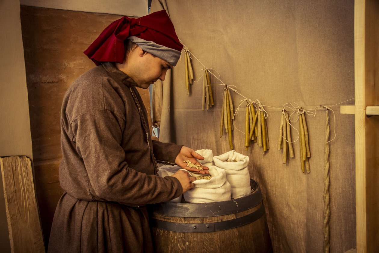 Historische re-enactment: Kaarsen en zakken met tarwe, rogge en gerst in de apotheek van Diotaiuti, Imola, Italië, midden 14e eeuw door Unbekannt Unbekannt