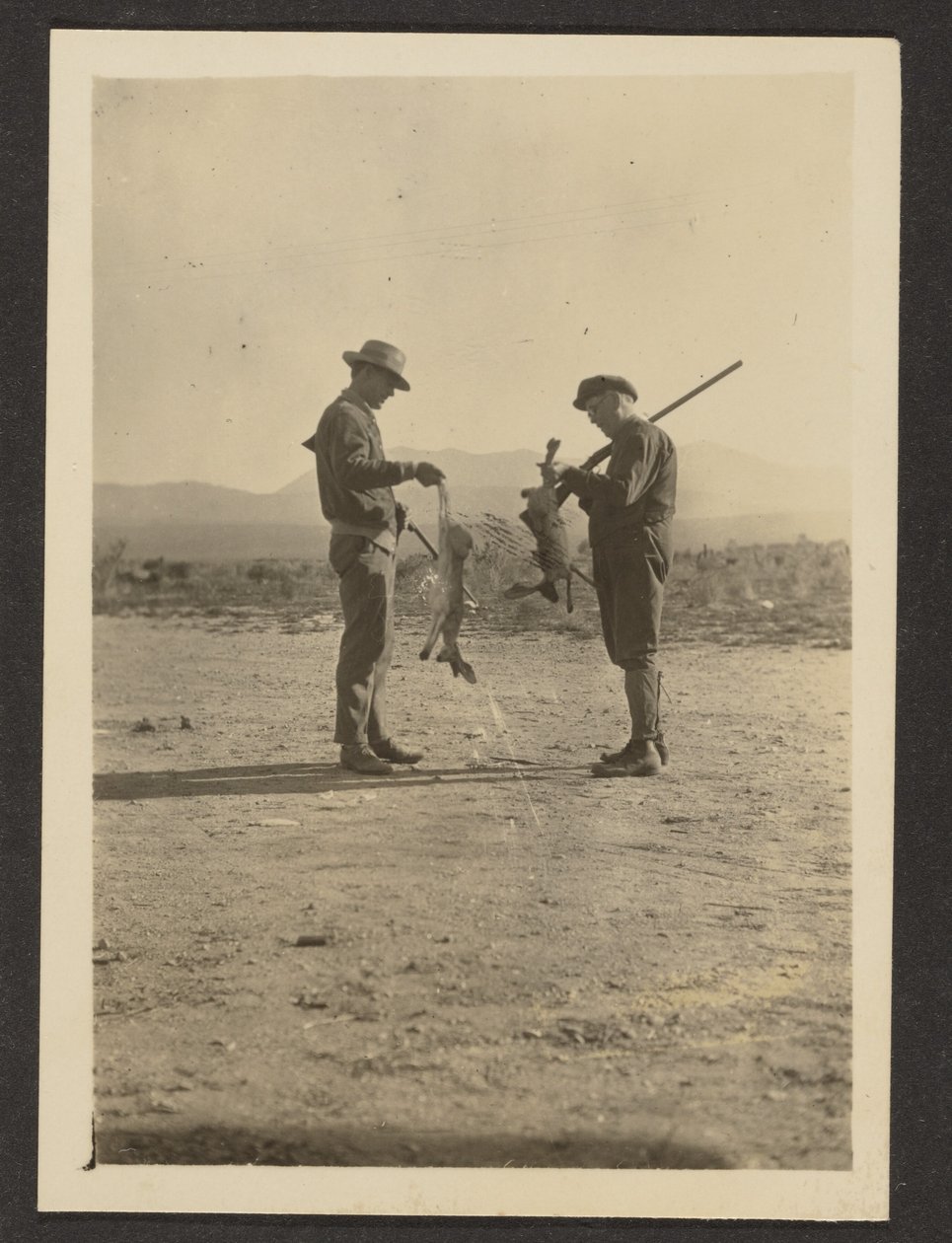 [Fleckenstein and Man Holding Guns and Dead Jackrabbits]. door Louis Fleckenstein