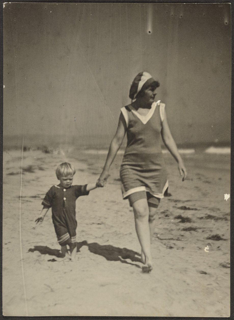 [Florence en kind wandelen op strand]. door Louis Fleckenstein
