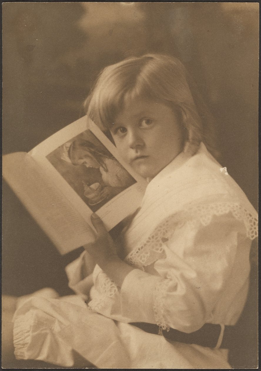 [Portret van een kind dat een boek openhoudt bij een soortgelijke illustratie] door Louis Fleckenstein