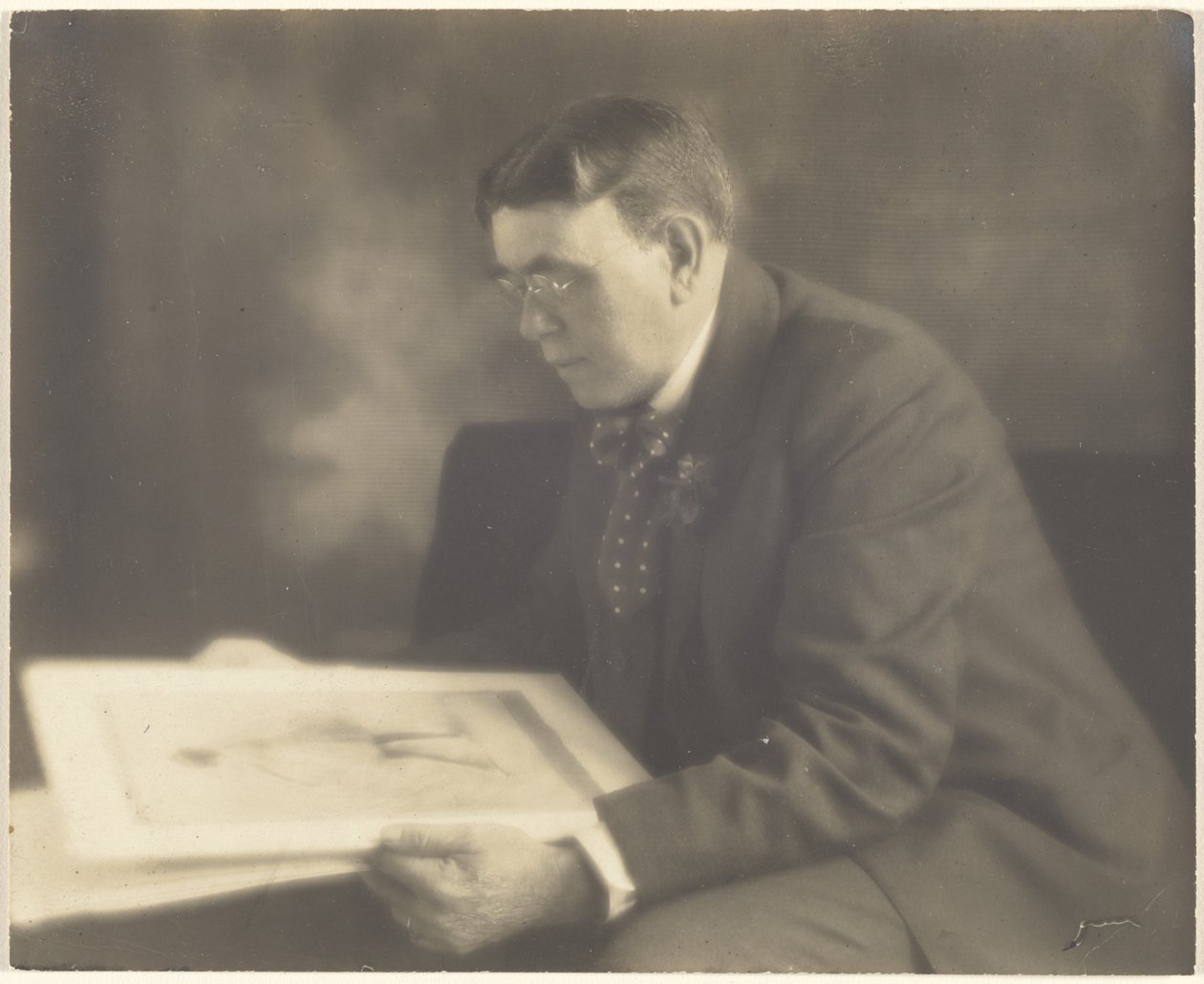 [Zelfportret in het atelier, terwijl ik een foto van een jong meisje bekijk] door Louis Fleckenstein
