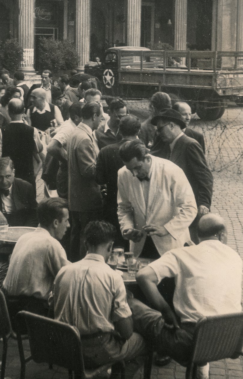 Wachtende tafels, op de achtergrond een vrachtwagen van het Amerikaanse leger door Luigi Leoni