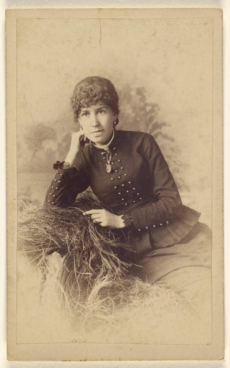 [Ongeïdentificeerde vrouw zittend met hand op wang, poserend op een stapel hooi]. door Miller and Company