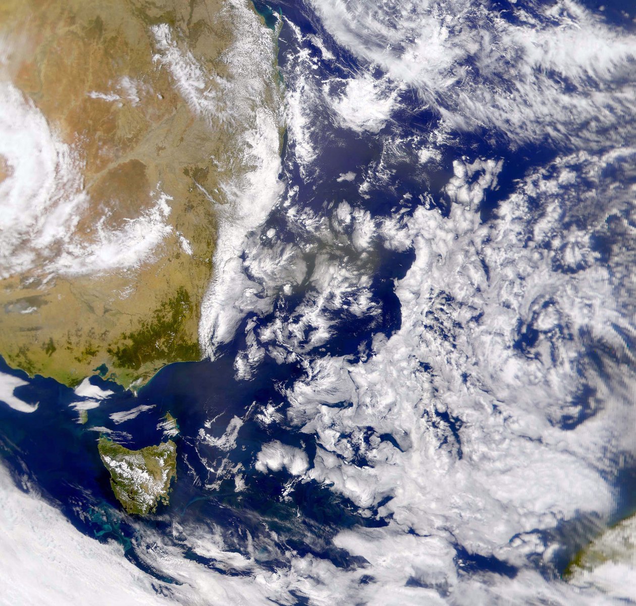 Satellietfoto van de Tasmanzee gedeeltelijk bedekt door wolken. Links is een deel van Australië met daaronder Tasmanië. NASA. Wetenschap door National Aeronautics and Space Administration National Aeronautics and Space Administration