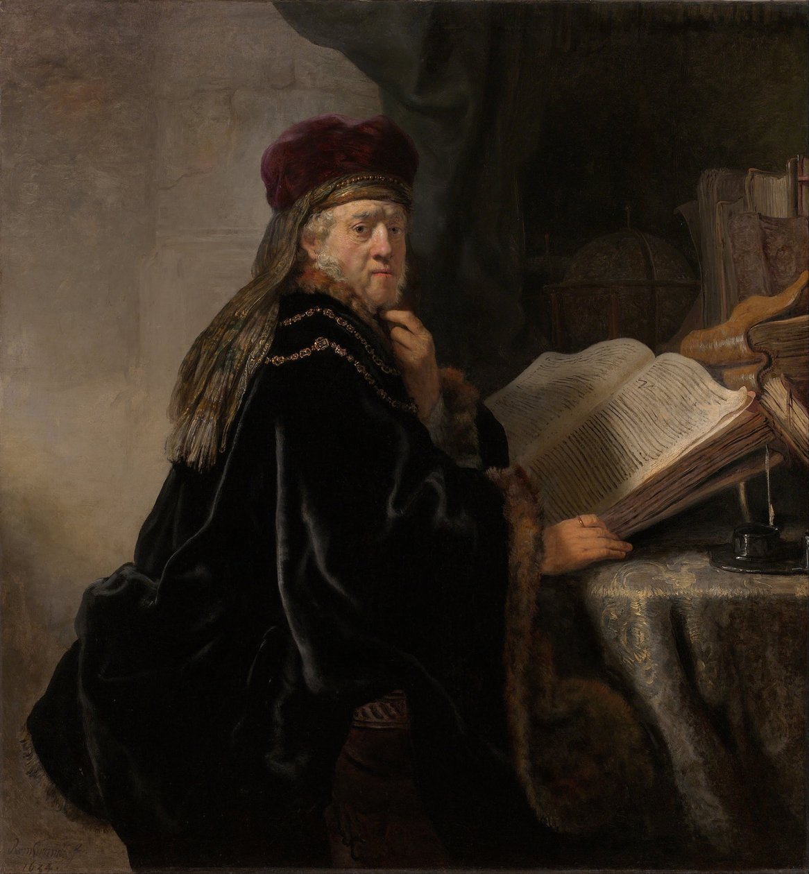 Een geleerde zittend aan een bureau door Rembrandt van Rijn