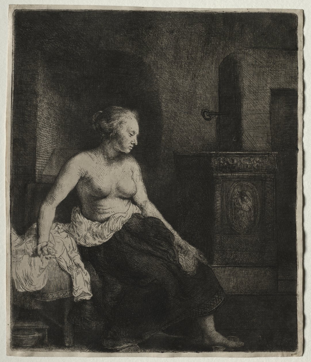 Zittende half aangeklede vrouw naast een kachel door Rembrandt van Rijn