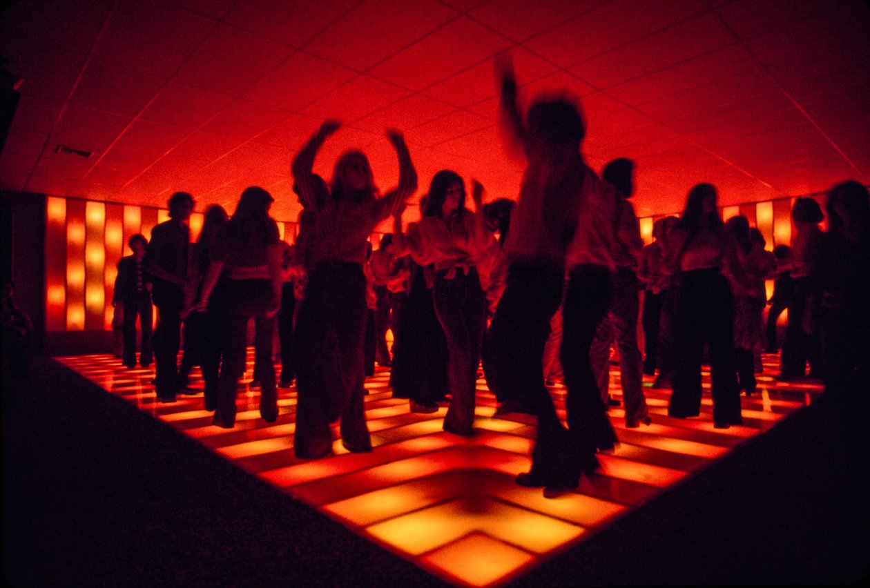Jonge dansers in een discotheek dansen op een verlichte vloer door Ted Spiegel