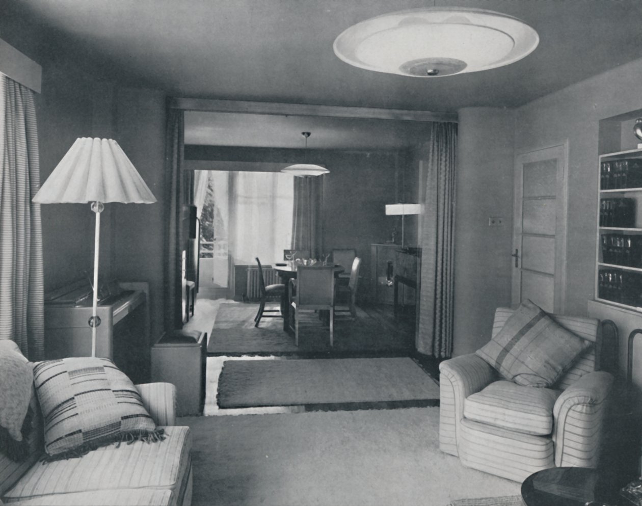 Eet- en woonkamer, gescheiden door zware gordijnen in een aantrekkelijke moderne weving, 1942 door Unbekannt