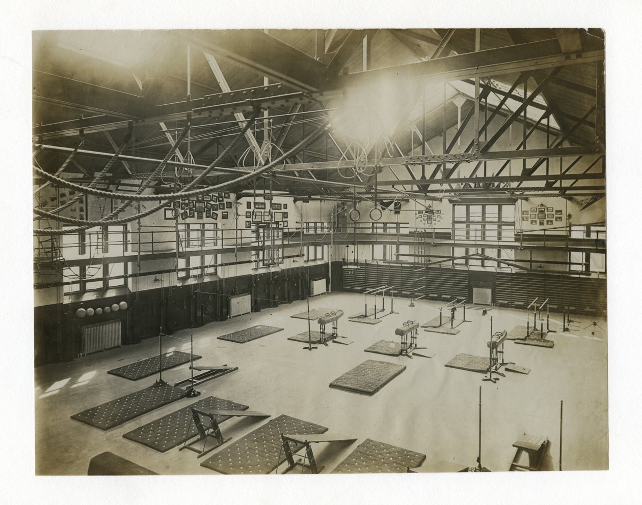 Horizontale foto van het interieur van een grote sportschool. Apparatuur en matten liggen verspreid over de vloer door Unbekannt