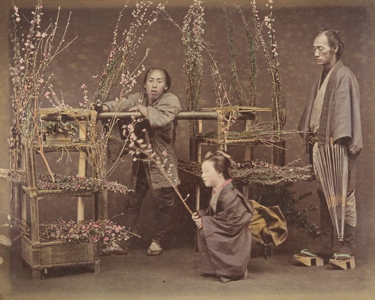 [Twee Japanse Mannen en Een Japanse Vrouw Poseren met Bloeiende Takken], 1870s door Unbekannt