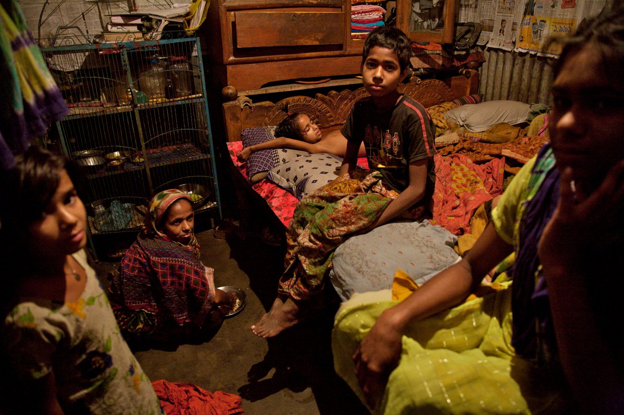 Een familie, in de bamboe sloppenwijk, nabij de Buriganga-rivier, in Oud-Dhaka, Bangladesh. 21 februari 2007. Zoveel als 6 tot 10 mensen wonen in kamers van 10 bij 10 voet, en delen een gemeenschappelijke handpomp, toilet en keuken tussen hen. De meeste me door Unbekannt Unbekannt
