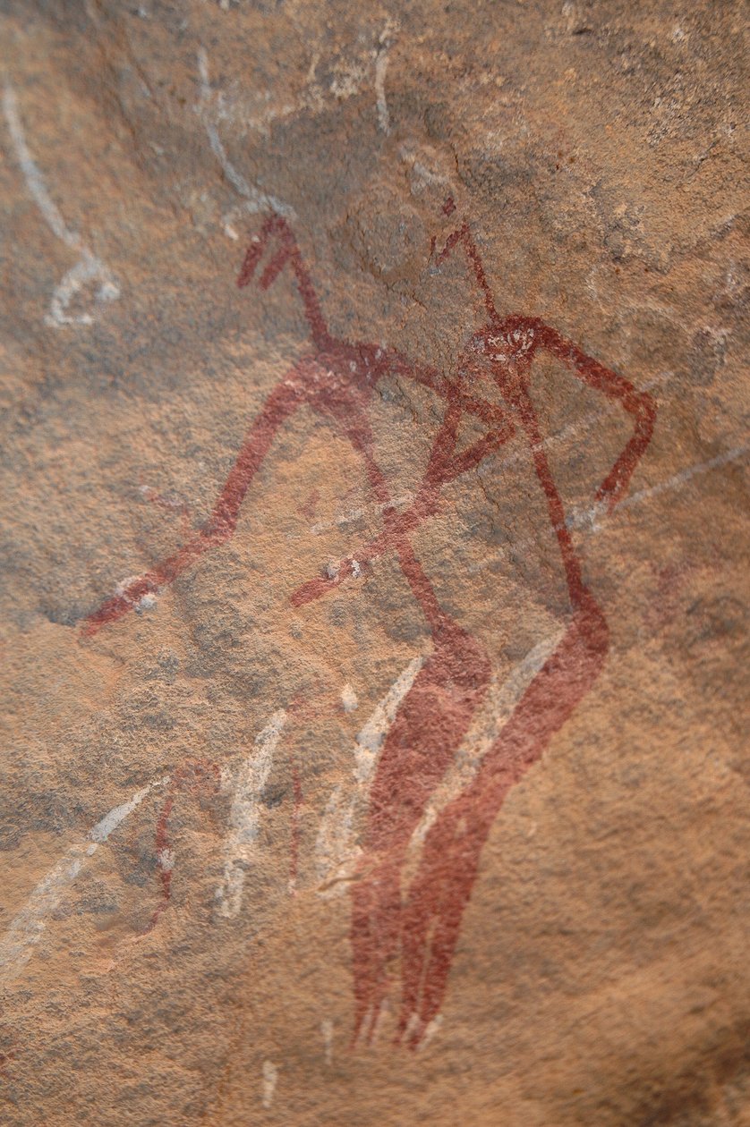 Rotstekeningen, Prehistorie: Rotsschildering van twee langgerekte figuren in een versierd onderkomen in de Uweinat-bergen, Soedan. Fotografie door Unbekannt