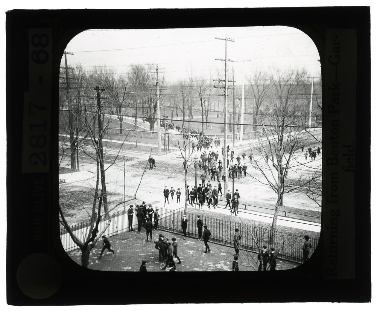 Horizontale, zwart-wit foto van jongens en meisjes die de straat oversteken om terug naar school te gaan na een uitstapje naar het park door Unknown