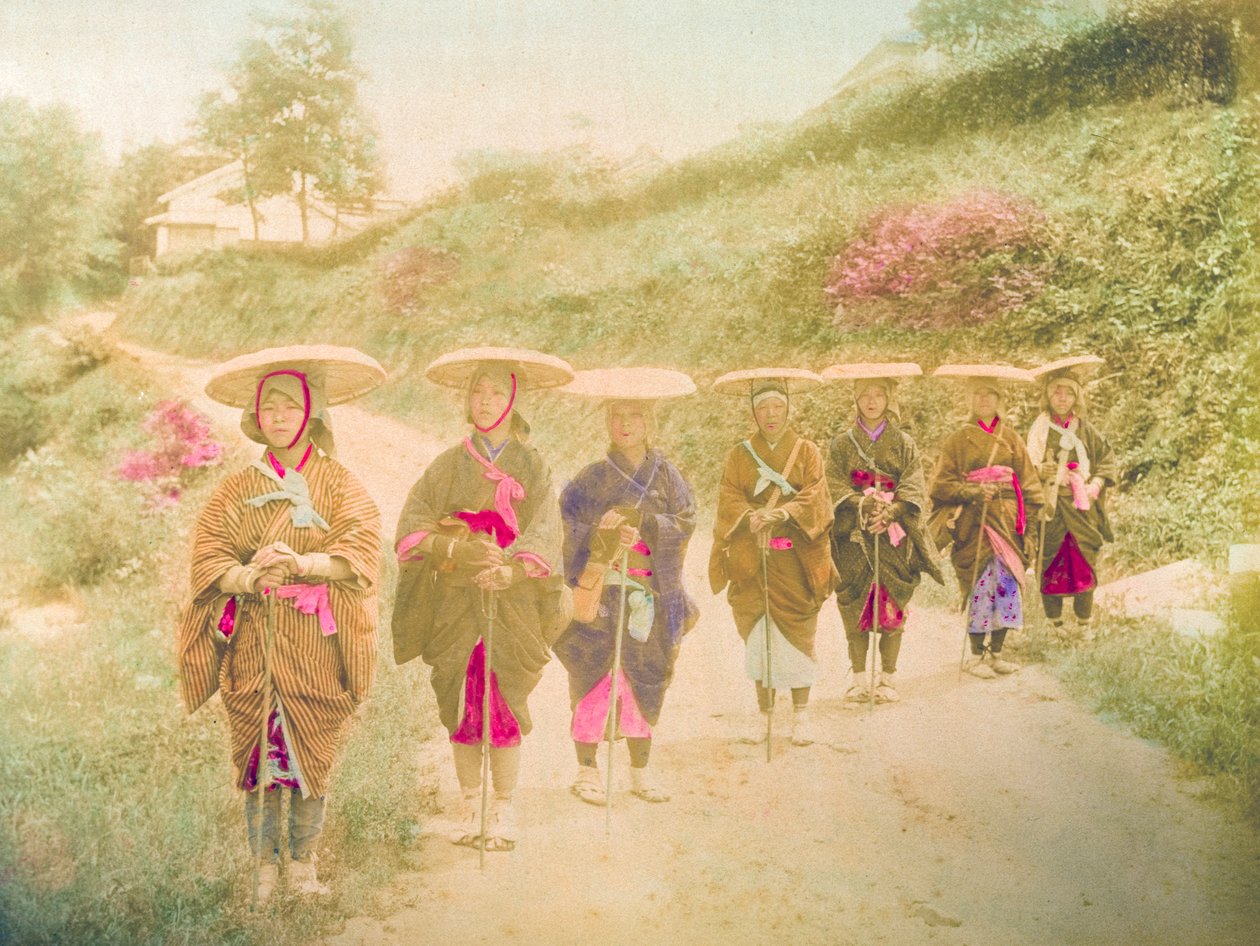 Japanse vrouwen. Zeven Japanse vrouwen staan in een rij op een landelijke weg. Japan, circa 1910. door Unknown photographer
