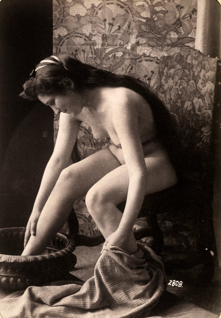 Portret van een naakte vrouw die haar voeten wast door Unknown photographer
